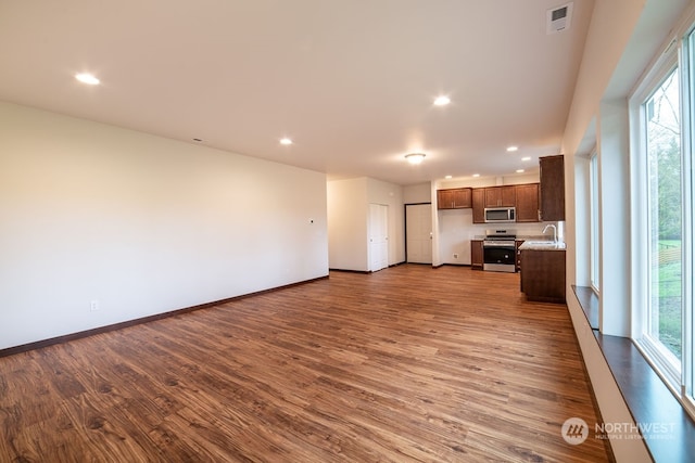 unfurnished living room with hardwood / wood-style floors and sink