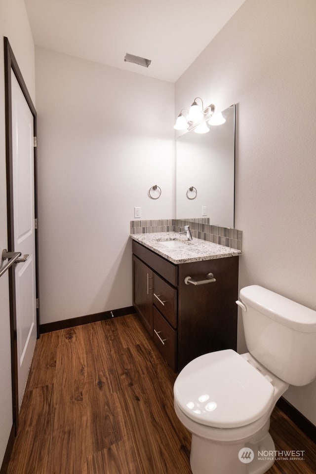 bathroom featuring vanity, wood-type flooring, and toilet