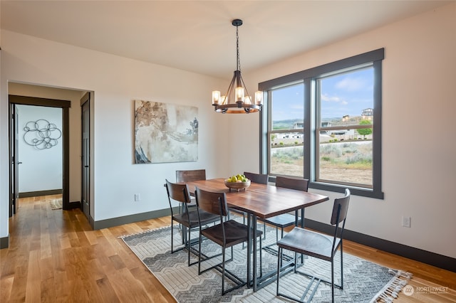 dining room with hardwood / wood-style flooring and a chandelier