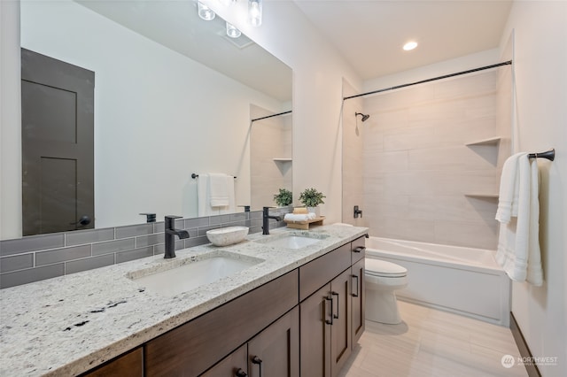 full bathroom with tiled shower / bath combo, tile flooring, toilet, and dual vanity