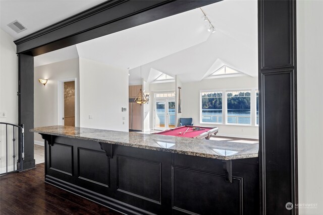 kitchen featuring dark wood-type flooring, track lighting, light stone countertops, lofted ceiling, and pool table