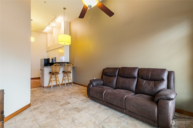 living room featuring rail lighting, light tile flooring, and ceiling fan