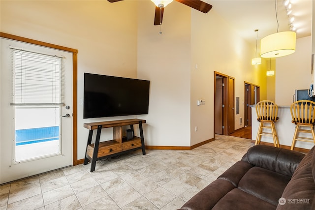 living room with light tile floors, rail lighting, and ceiling fan