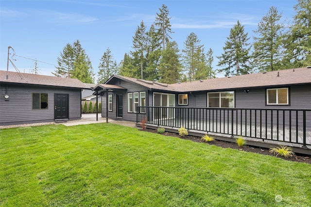 back of house with a deck and a yard