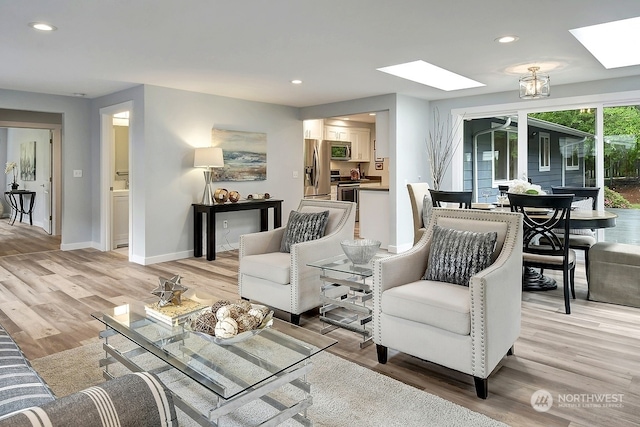 living room with a skylight and light hardwood / wood-style floors