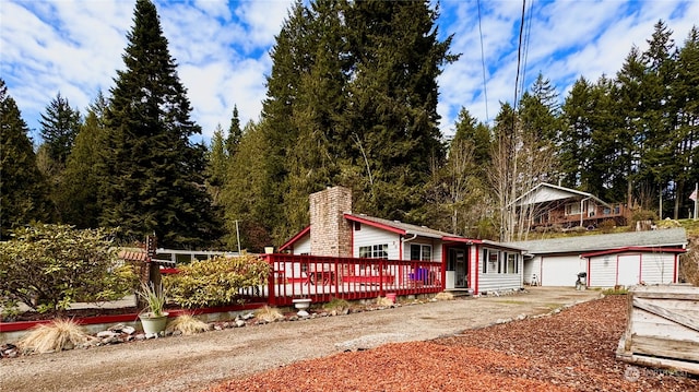 view of front of home featuring a wooden deck, an outdoor structure, and a garage