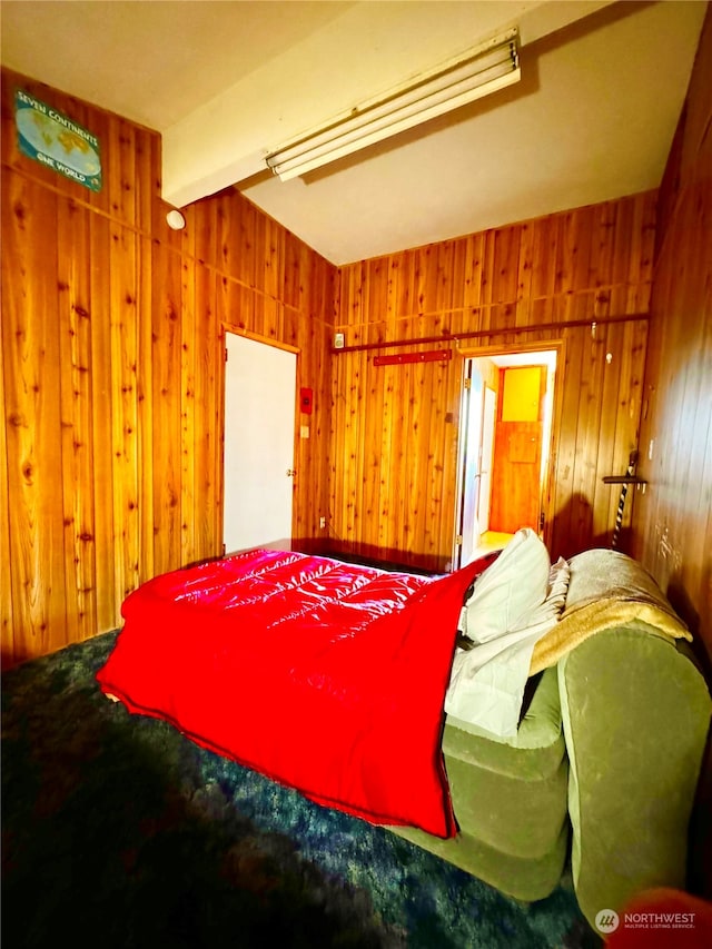 bedroom featuring beamed ceiling and wood walls