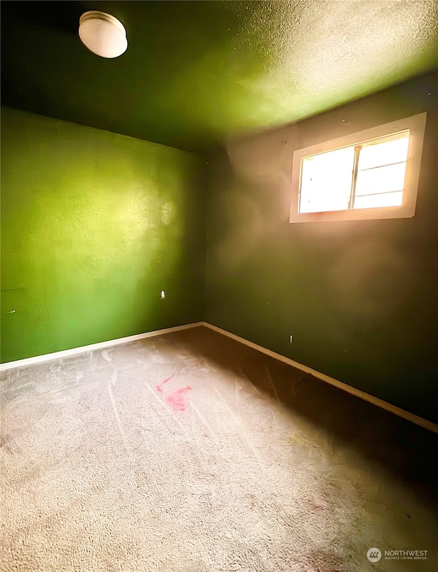 empty room with a textured ceiling and carpet