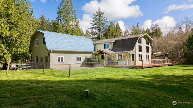 rear view of house with a deck and a yard