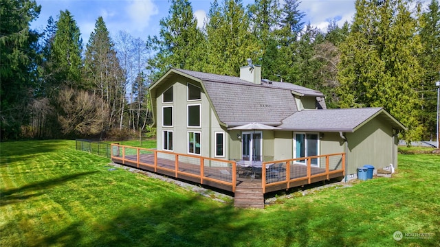 back of house with a wooden deck and a yard