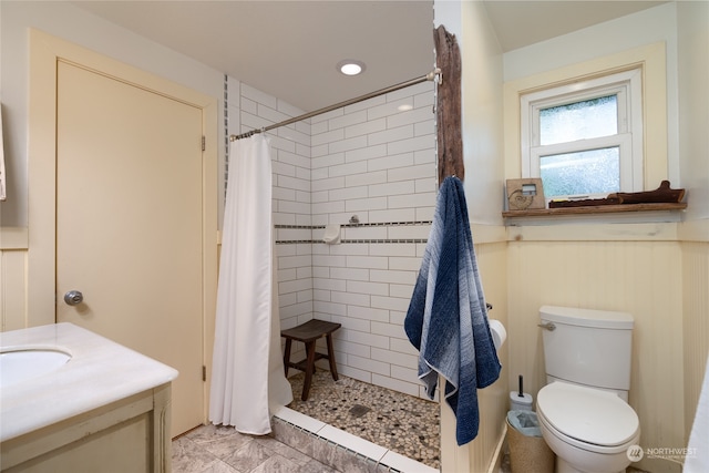 bathroom with tile floors, a shower with curtain, toilet, and vanity