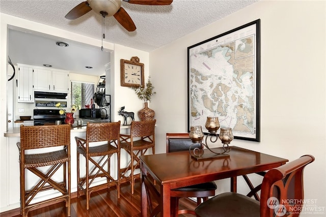 dining area featuring a textured ceiling, ceiling fan, and hardwood / wood-style flooring