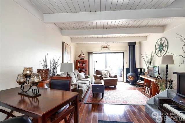 living room featuring wood-type flooring, a wood stove, and beamed ceiling