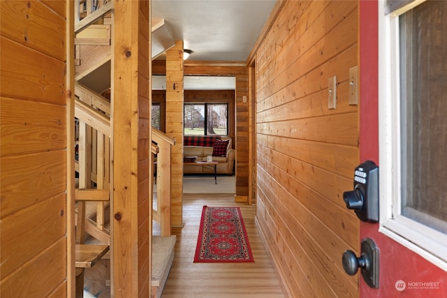 hallway with wooden walls and light wood-type flooring