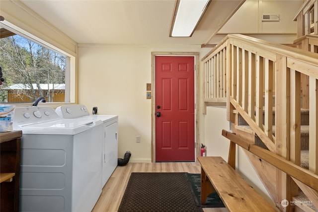 laundry room with separate washer and dryer and light wood-type flooring