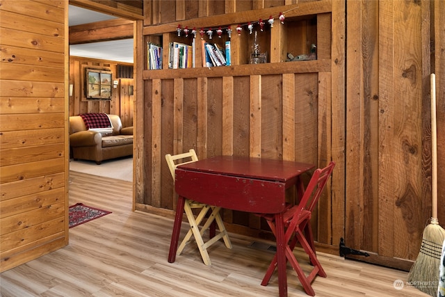 dining room with wooden walls and light hardwood / wood-style floors