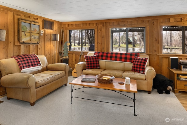 living room with light hardwood / wood-style floors and wood walls