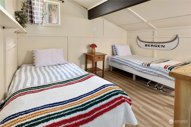 bedroom with light wood-type flooring and lofted ceiling