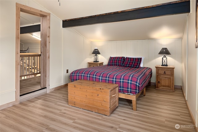 bedroom featuring lofted ceiling with beams and light wood-type flooring