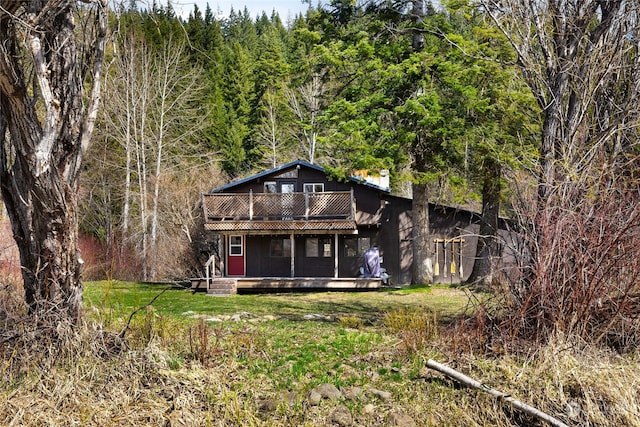 back of property featuring a lawn and a balcony