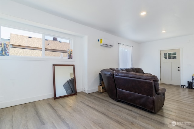 living room with light hardwood / wood-style floors and a wall unit AC