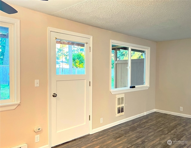 entrance foyer with ceiling fan, a textured ceiling, and dark wood-type flooring