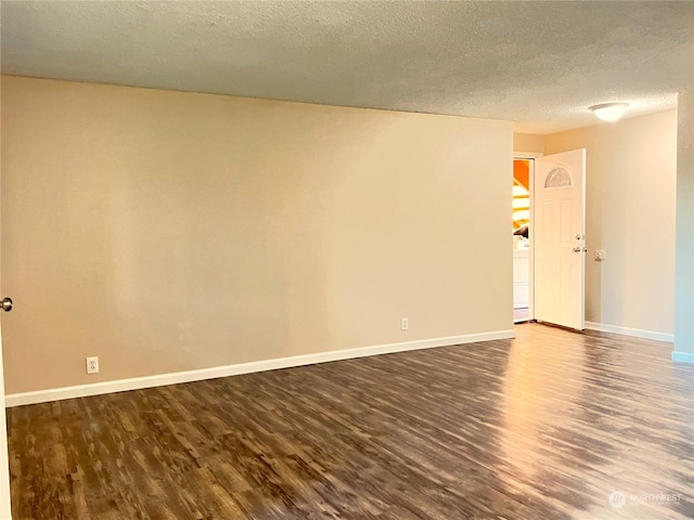 spare room with dark hardwood / wood-style floors and a textured ceiling