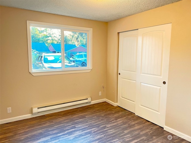 unfurnished bedroom featuring a closet, a baseboard radiator, dark hardwood / wood-style floors, and a textured ceiling