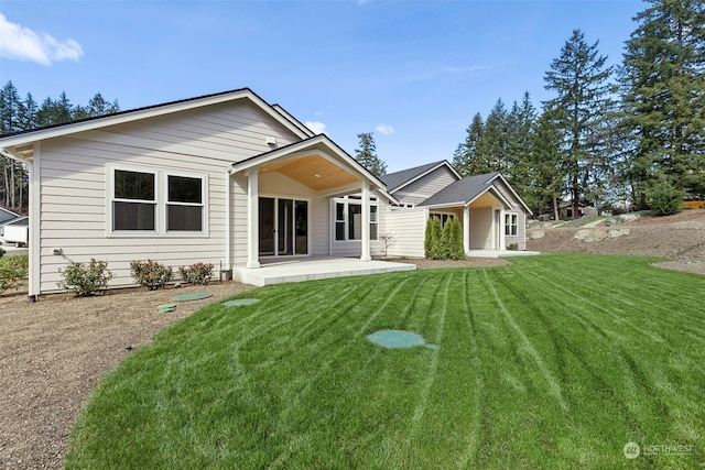 rear view of property featuring a patio area and a yard