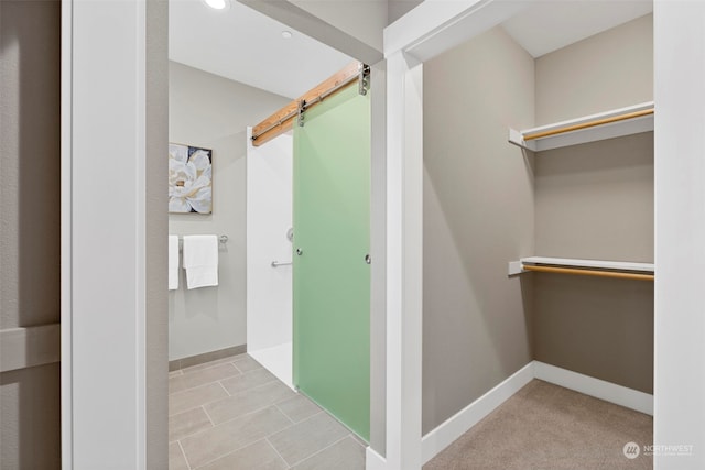 interior space featuring light colored carpet and a barn door