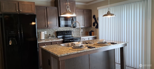 kitchen with a center island, decorative light fixtures, light stone countertops, tasteful backsplash, and black appliances