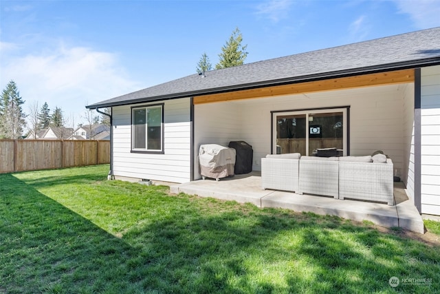 rear view of house featuring a lawn and a patio