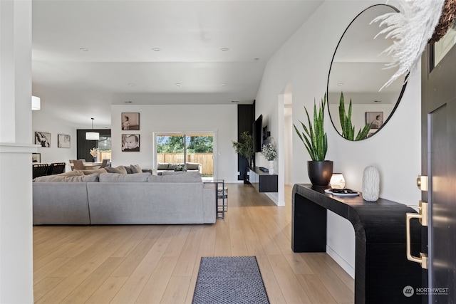 living room featuring lofted ceiling and light hardwood / wood-style flooring