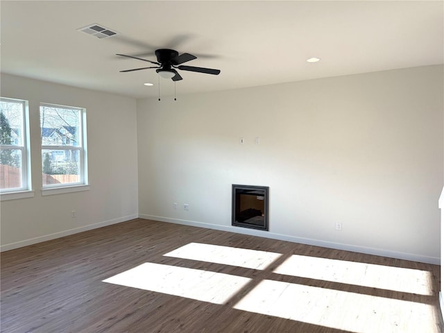 unfurnished room with ceiling fan and dark wood-type flooring