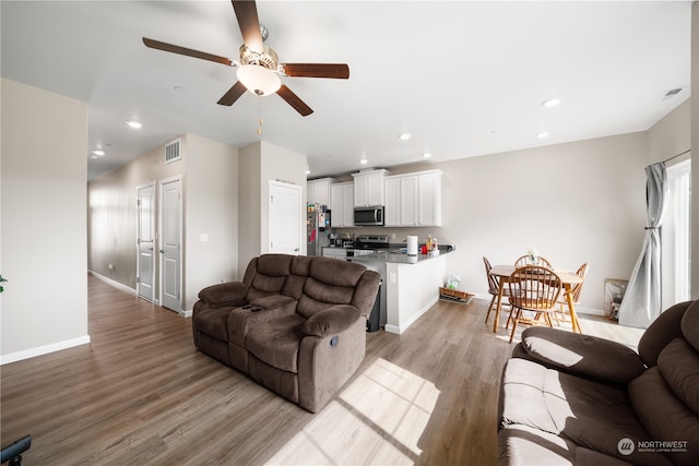 living room featuring light hardwood / wood-style floors and ceiling fan