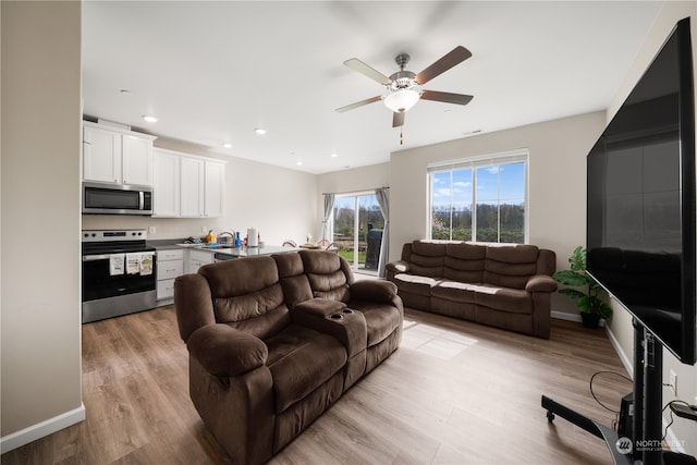 living room featuring ceiling fan and light wood-type flooring