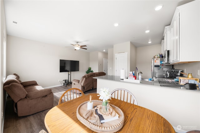 dining space with hardwood / wood-style floors and ceiling fan