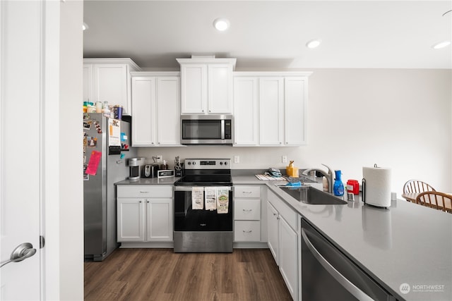 kitchen featuring white cabinetry, appliances with stainless steel finishes, and dark wood-type flooring