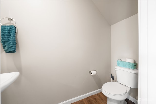 bathroom featuring hardwood / wood-style floors, toilet, and vaulted ceiling