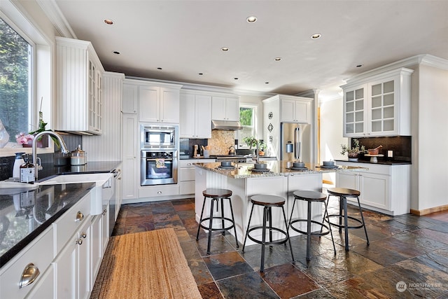 kitchen featuring a center island, tasteful backsplash, a wealth of natural light, and white cabinets