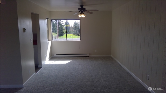 empty room featuring a baseboard heating unit, wooden walls, ceiling fan, and carpet flooring