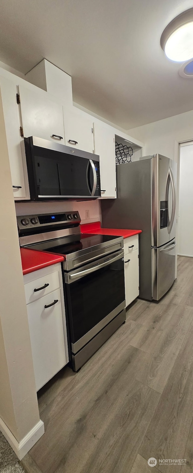 kitchen featuring white cabinetry, light hardwood / wood-style flooring, and stainless steel appliances