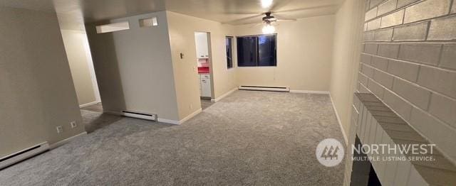 corridor with a baseboard heating unit and carpet flooring