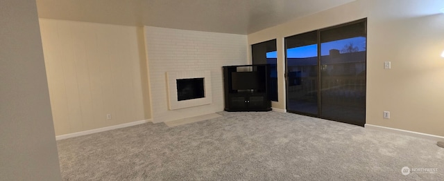 unfurnished living room with a large fireplace and light carpet