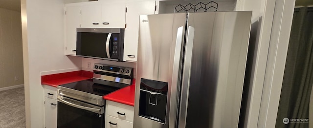 kitchen featuring stainless steel appliances, carpet flooring, and white cabinets