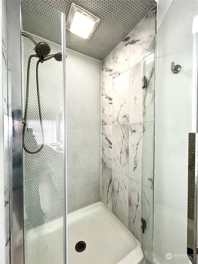 bathroom featuring a shower with door