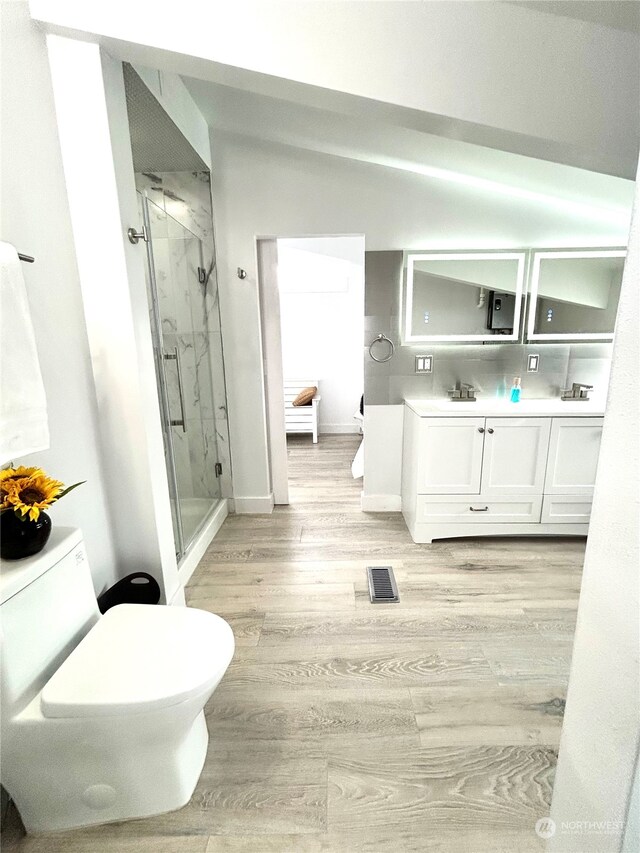 bathroom with hardwood / wood-style floors, vanity, and walk in shower