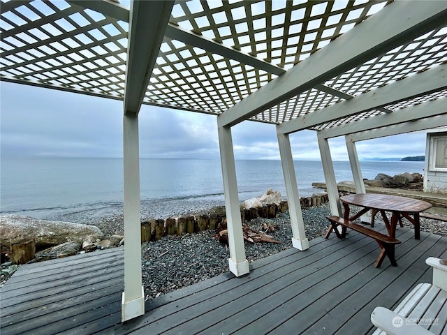 wooden terrace featuring a water view and a view of the beach