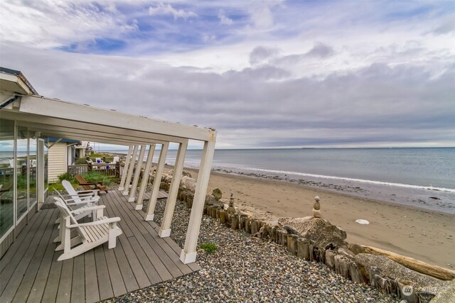 deck featuring a view of the beach and a water view