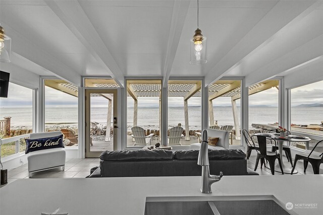 sunroom featuring a water view